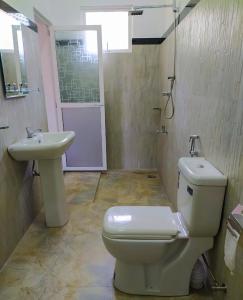 un baño con inodoro y lavabo en River Side Holiday Inn, en Weligama