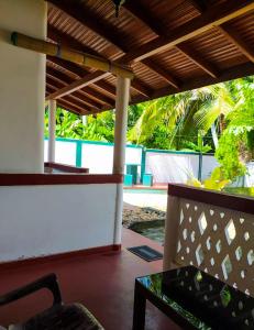 porche con banco y vistas a la piscina en River Side Holiday Inn, en Weligama
