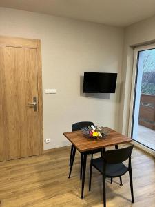 a dining room with a table and chairs and a television at Apartamenty Polna 60 in Żory