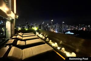 a row of beds on a balcony with a city skyline at The Gramercy Residences in Manila