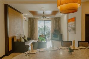 a dining room with a table and a living room at Borneo Beach Villas in Kota Kinabalu
