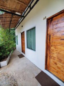 a house with a wooden door and a patio at Cheeva at pai ชีวา แอท ปาย in Pai