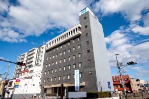 a tall building with a sign on top of it at le Lac HOTEL Otsu Ishiyama in Otsu