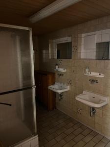 a bathroom with two sinks and a refrigerator at Vesperstube Michelbach in Gaggenau