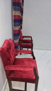 a couple of red chairs sitting in a room at Karachi Guest House - Gulshan in Karachi