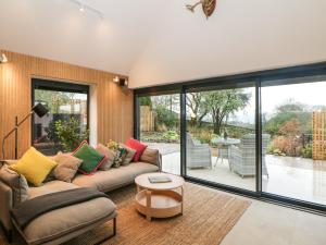 a living room with a couch and a table at Overlea Coach House in Birch Vale