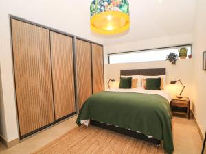 een slaapkamer met een groot bed en een groot raam bij Overlea Coach House in Birch Vale