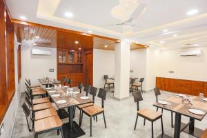 um restaurante com mesas e cadeiras num quarto em FabHotel Golf Inn Golf Course Road Gurgaon em Gurgaon