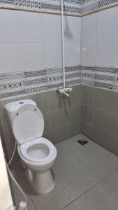 a bathroom with a white toilet in a stall at Karachi Guest House - Gulshan in Karachi