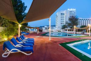 un grupo de tumbonas junto a la piscina en Al Falaj Hotel en Mascate