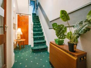 a hallway with a staircase with a green carpet at Chesterton Hotel, Blackpool South Shore in Blackpool