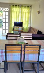 un soggiorno con tavolo in legno e 2 sedie di Bodhee Villa a Grand Baie