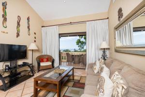 sala de estar con sofá y TV en El Diria 301 Penthouse- Ocean View 3 Bedroom Condo, en Tamarindo