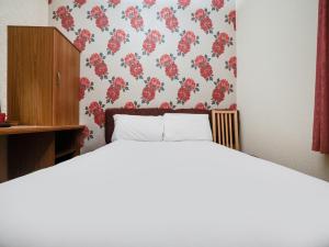 a bedroom with a bed with a floral wallpaper at Chesterton Hotel, Blackpool South Shore in Blackpool