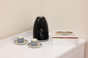 a coffee maker and two cups on a table at Bernini House Naples in Naples