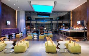 a lobby with yellow chairs and a bar at Workinn Hotel in Gebze