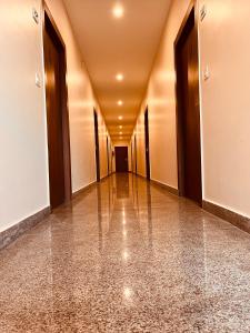 an empty corridor of a building with wooden doors at Hotel Prayag INN Haridwar in Haridwār