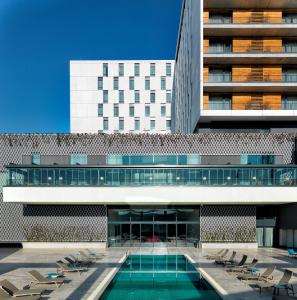 an external view of a building with a swimming pool at Workinn Hotel in Gebze