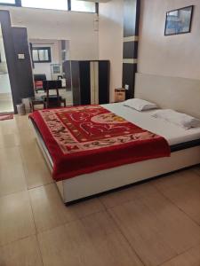 a bedroom with a bed with a red blanket on it at JAIN HOTEL,Pachmarhi in Pachmarhī