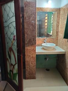 a bathroom with a sink and a mirror at JAIN HOTEL,Pachmarhi in Pachmarhī