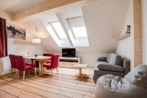 ein Wohnzimmer mit einem Tisch und roten Stühlen in der Unterkunft Konrad-Haus - DorfResort Mitterbach in Mitterbach