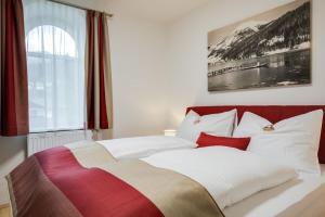 um quarto com uma cama grande com almofadas brancas e vermelhas em Konrad-Haus - DorfResort Mitterbach em Mitterbach