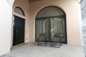 two chairs sitting on a patio with windows at I Platani in Lezzeno