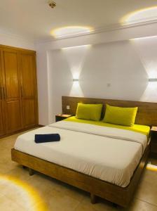 1 dormitorio con 1 cama grande con almohadas amarillas en Elegant 3 bedrooms apartment ikoyi en Lagos