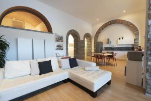a living room with a white couch and a kitchen at I Platani in Lezzeno +41 photos