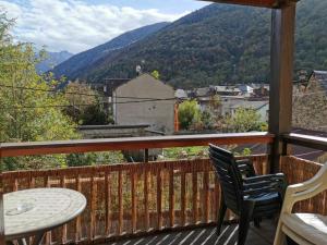 a balcony with a table and chairs and mountains at Beau T3 place parking, vue dégagée proche centre in Luchon