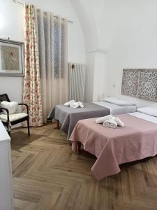 2 camas en una habitación con suelo de madera en La Casa Di Chia, en Trepuzzi