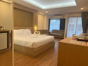 a bedroom with a bed and a living room at เดอะสแควร์โฮเทลนครพนม in Nakhon Phanom