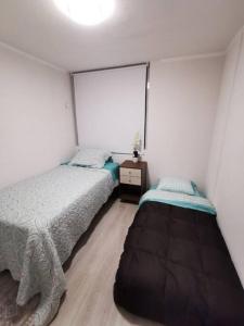 1 dormitorio con 2 camas y ventana grande en Departamento a pasos de la playa avenida del mar, en La Serena