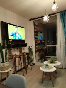 sala de estar con TV de pantalla plana en la pared en Departamento a pasos de la playa avenida del mar, en La Serena