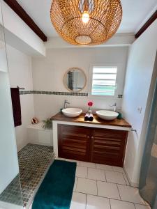 a bathroom with two sinks and a mirror at JOLIE CREOLE- Villa sur le lagon in La Saline les Bains