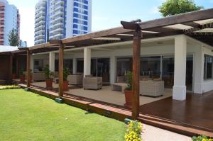 a deck with chairs and tables on a building at Appartamento Long Beach in Punta del Este