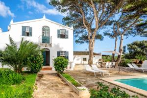 a white house with a swimming pool and a yard at Villa Torret 46 in Sant Lluis