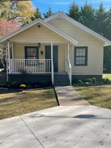 ein kleines Haus mit einer Veranda und einer Auffahrt in der Unterkunft Frank Howard 111 Farmhouse in Clemson