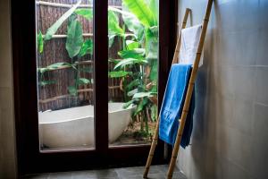 ein Badezimmer mit einer Badewanne neben einem Fenster in der Unterkunft An Bang Seastar Boutique Villa in Hoi An