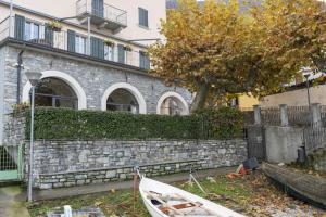 a white boat sitting in front of a building at I Platani in Lezzeno