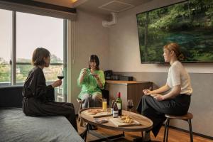 a group of three women sitting around a table with wine at Hotel Ten to Ten in Sapporo