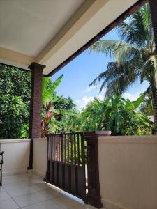 a balcony with a view of a palm tree at NusaTuah Roomstay in Melaka
