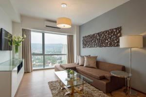 a living room with a couch and a glass table at Quest Serviced Residences in Cebu City