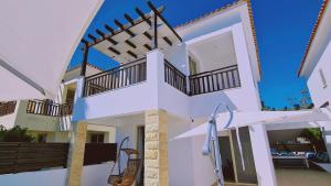 ein weißes Haus mit zwei Balkonen in der Unterkunft STAY Panorama - Kamelia Villa in Peyia