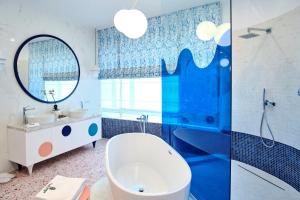 a bathroom with a tub and a sink and a mirror at Vilacrosse Boutique Inn in Bucharest