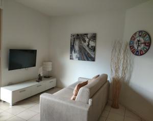 a living room with a couch and a tv at APPARTAMENTI TICINO in Sesto Calende