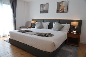 um quarto com uma grande cama branca e uma cabeceira preta em Hayes Hotel, Addis Ababa em Addis Ababa