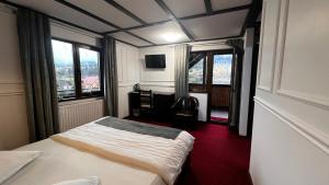 クンプルング・モルドヴェネスクにあるRoyal Bucovina Residence Adults Only-Self check-inのベッドと窓のあるホテルの部屋