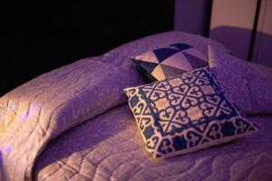 a purple bed with two pillows on top of it at Bed&Dreams in Salento Suite con spa privata esclusiva in Guagnano