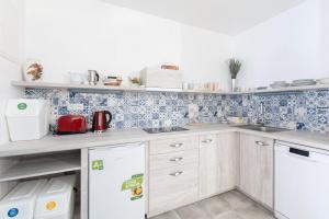 a kitchen with blue and white tiles on the wall at Apartmány Uprostřed zeleně in Lednice